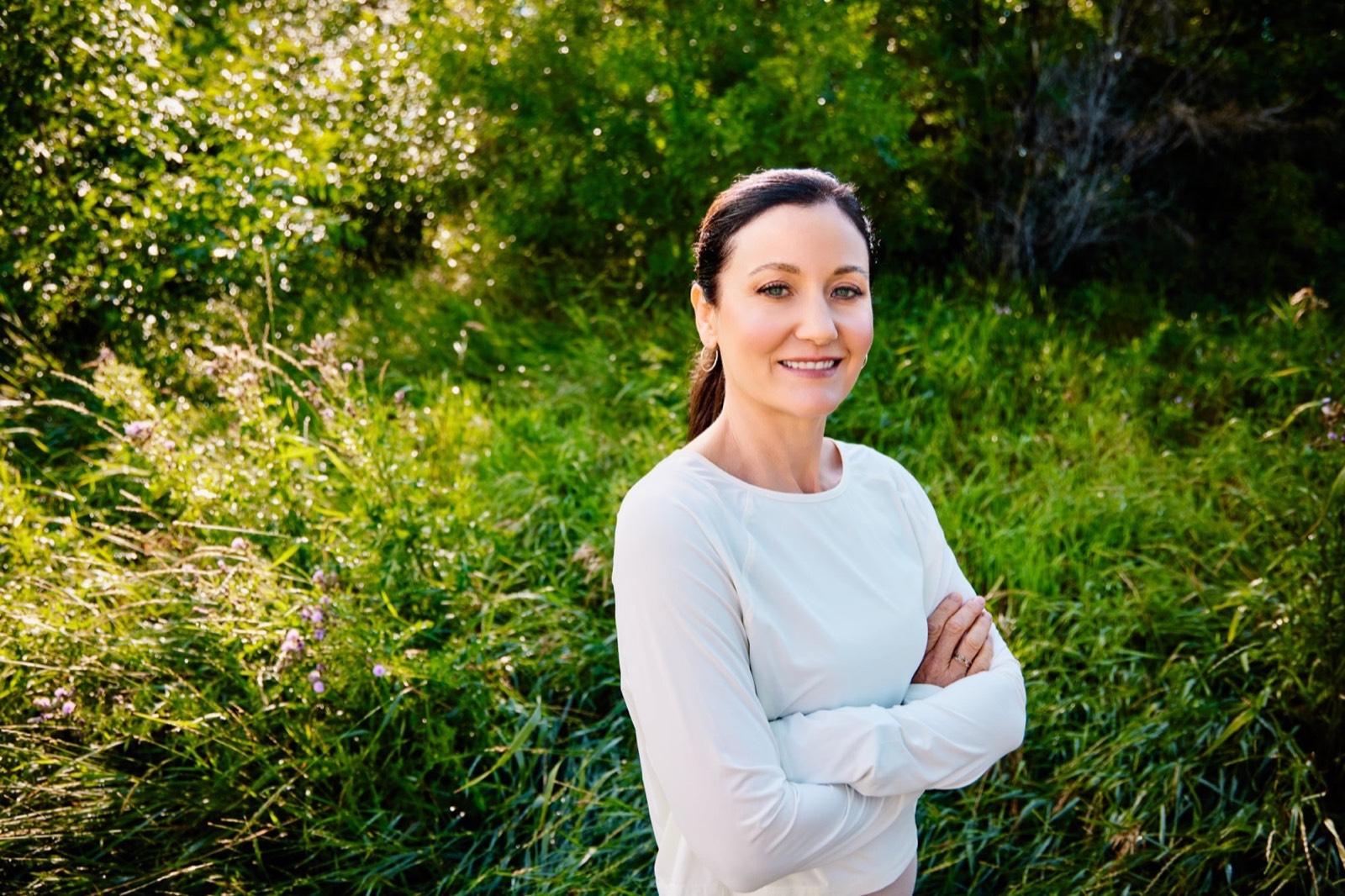 April smiling outdoors among tall green grass